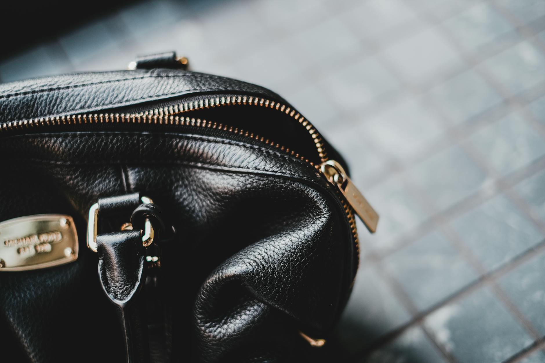 Close-up of a structured designer leather handbag on a neutral surface