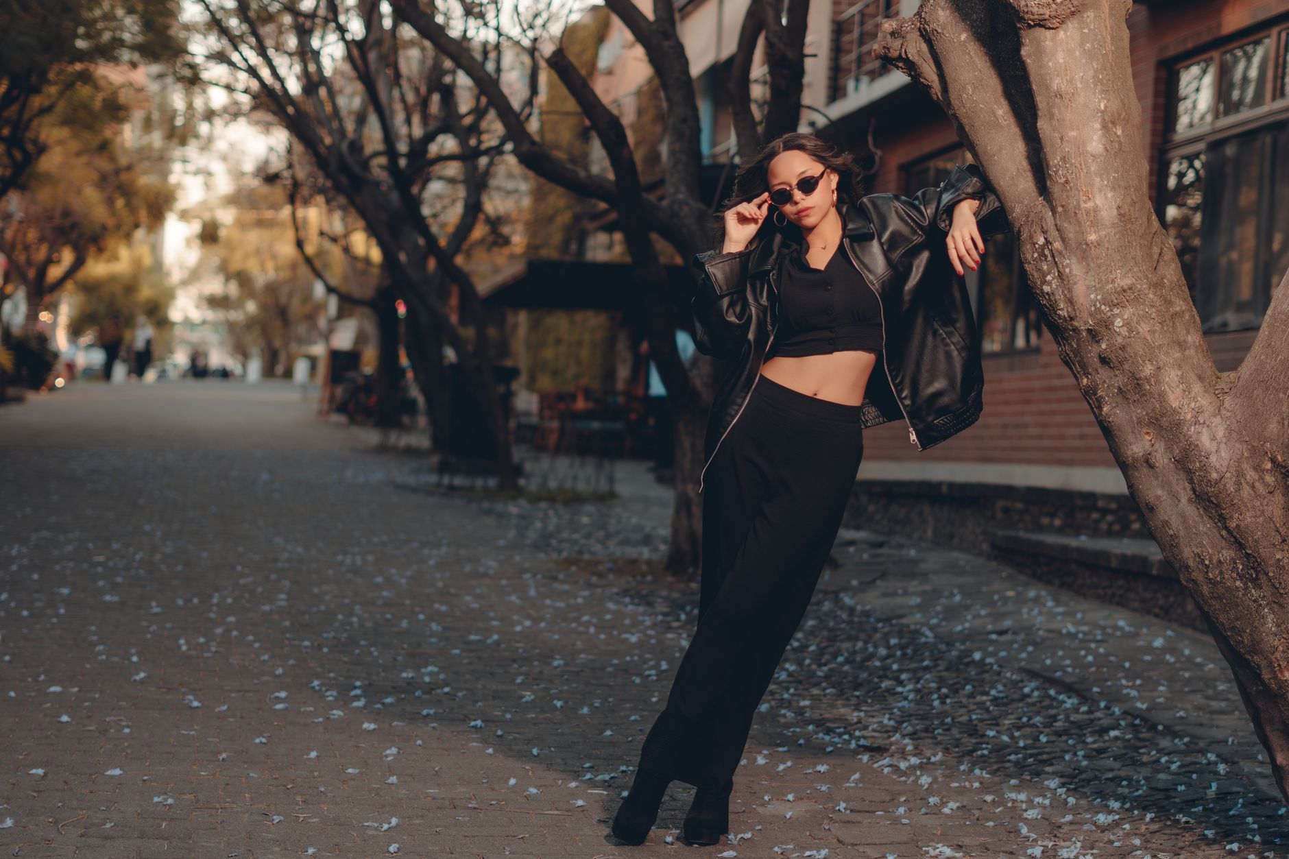 A person in minimal, well-layered autumn clothing walking on a city street