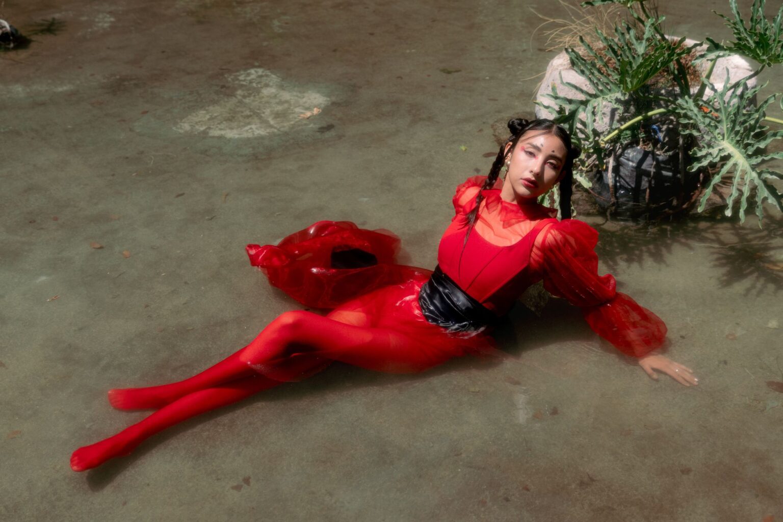 A bold red fashion editorial look showcasing luxury garment construction and fabric quality