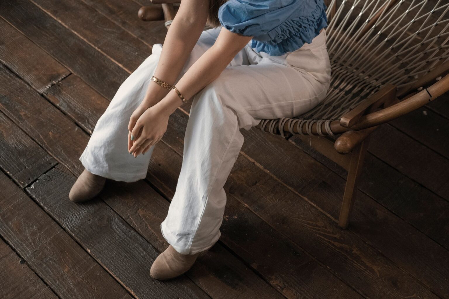 Woman wearing flowing, high-waisted fluid trousers in neutral tones