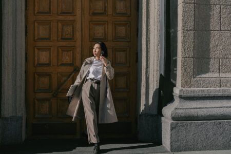 Woman wearing a structured belted trench coat on a city street