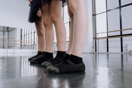 Close-up of a sleek leather ballet flat on a wooden floor
