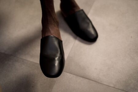 Close-up of minimalist leather flat shoes on a clean surface