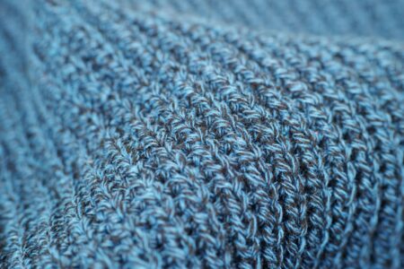 Close-up of fine-gauge knit mule shoes in neutral tone on a clean surface