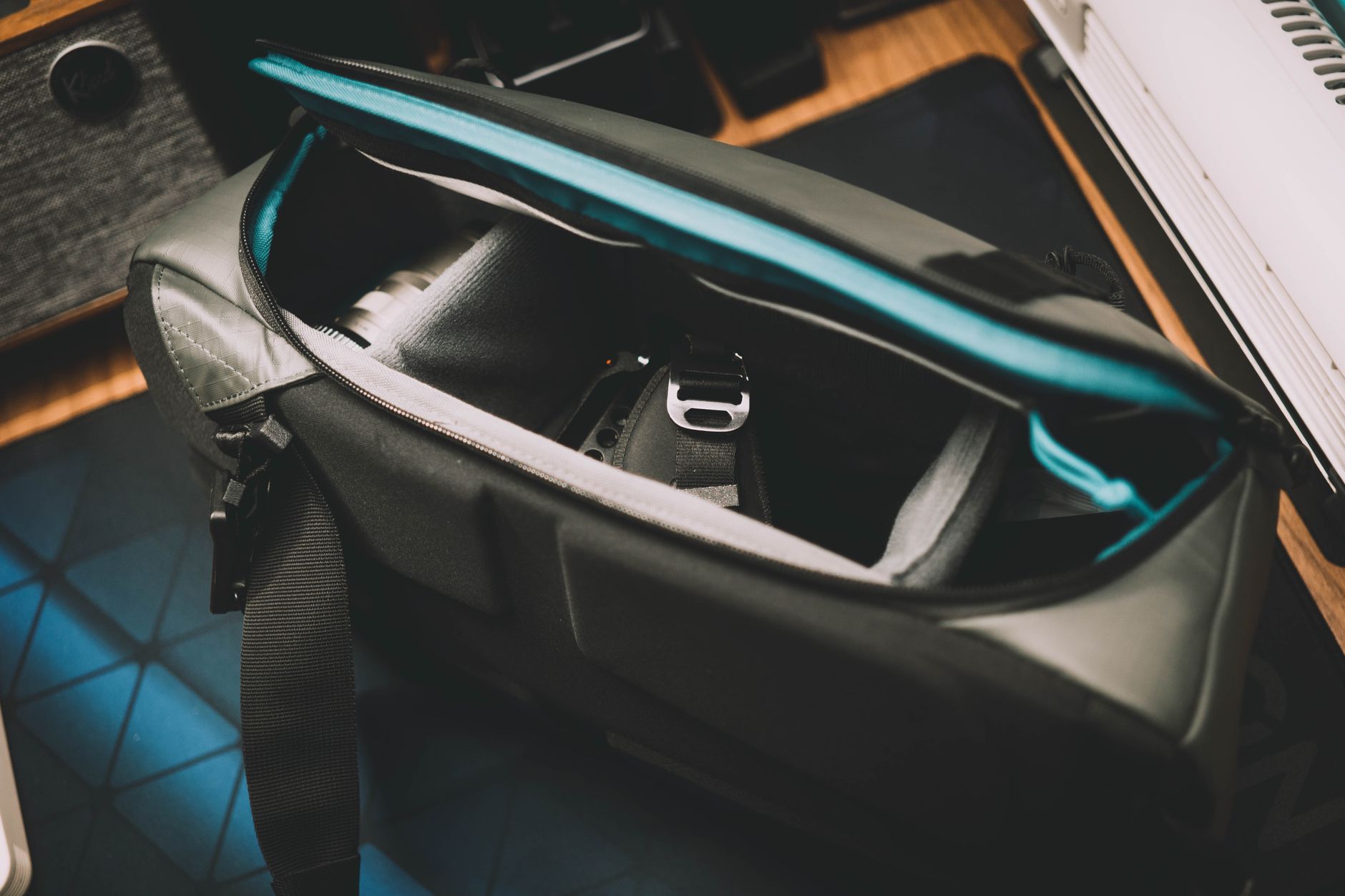 Close-up of a structured nylon shoulder bag with minimal hardware on a neutral background