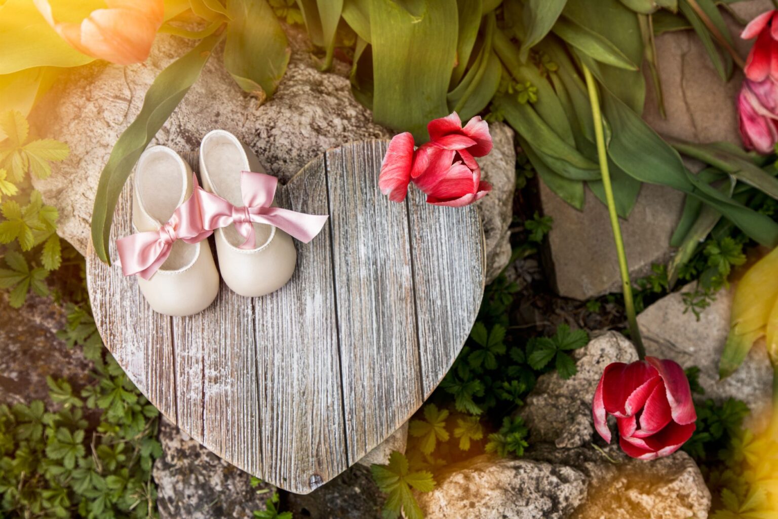 Close-up of decorative embellished flat shoes with pearl and floral detailing on a neutral background