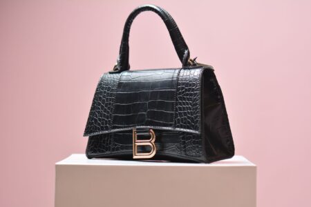 Close-up of a structured canvas luxury handbag with subtle geometric pattern