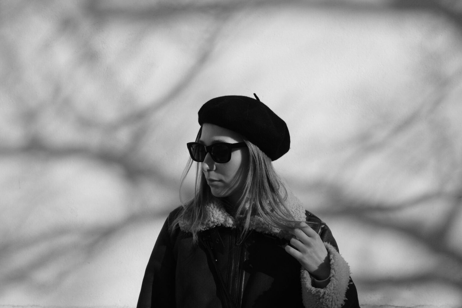 Loro Piana’s Cashmere Beret Is Quietly Edging Out the Baseball Cap A woman wearing a fitted cashmere beret with a tailored coat in an urban setting