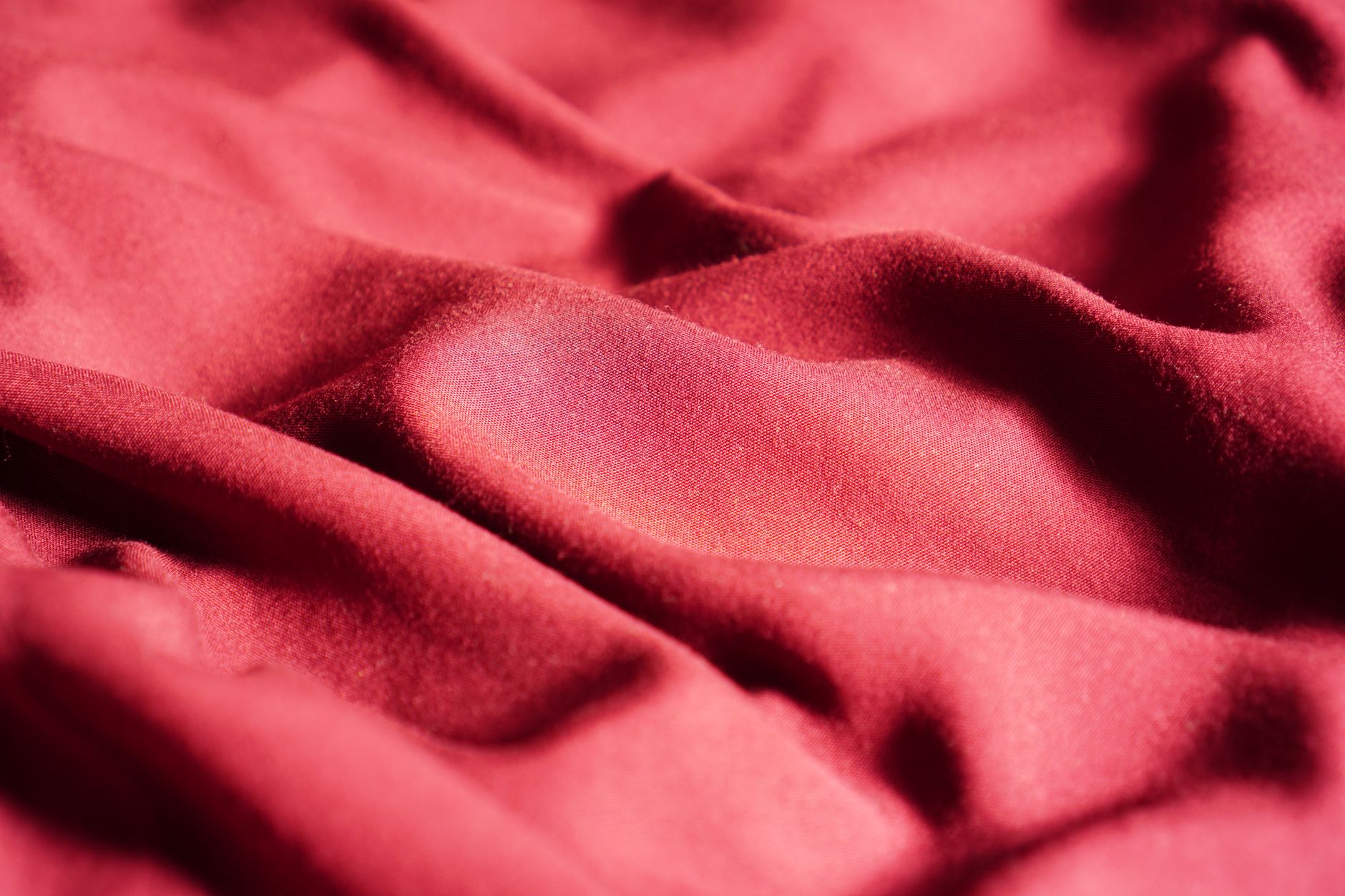 Close-up of rich red fabric texture highlighting depth and quality of high-end textile