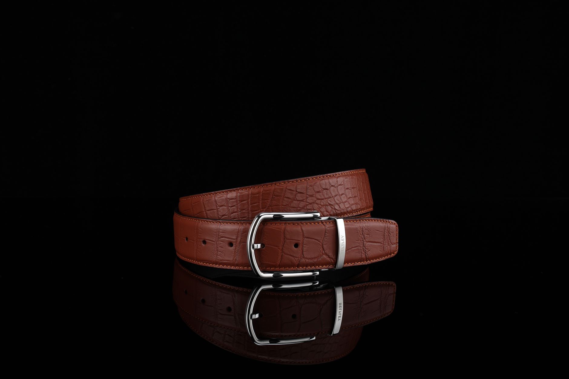 Close-up of structured leather bag with minimal hardware on a neutral surface
