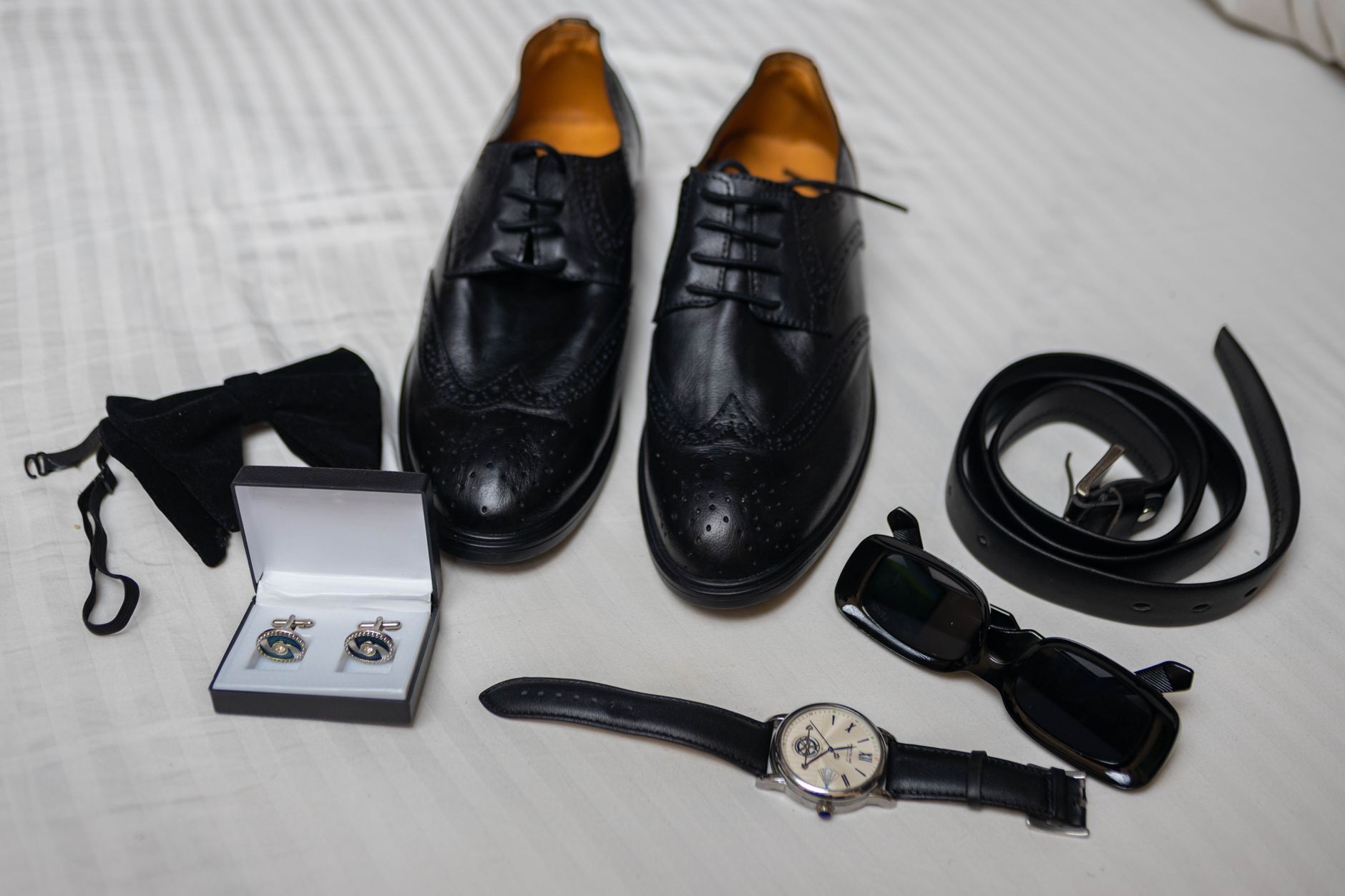 Elegant evening accessories including a leather clutch laid flat on silk fabric