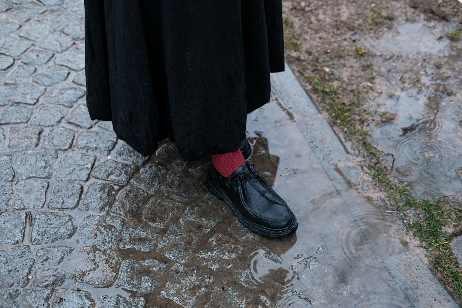 Close-up of casual shoes worn with wide-leg denim on a city street