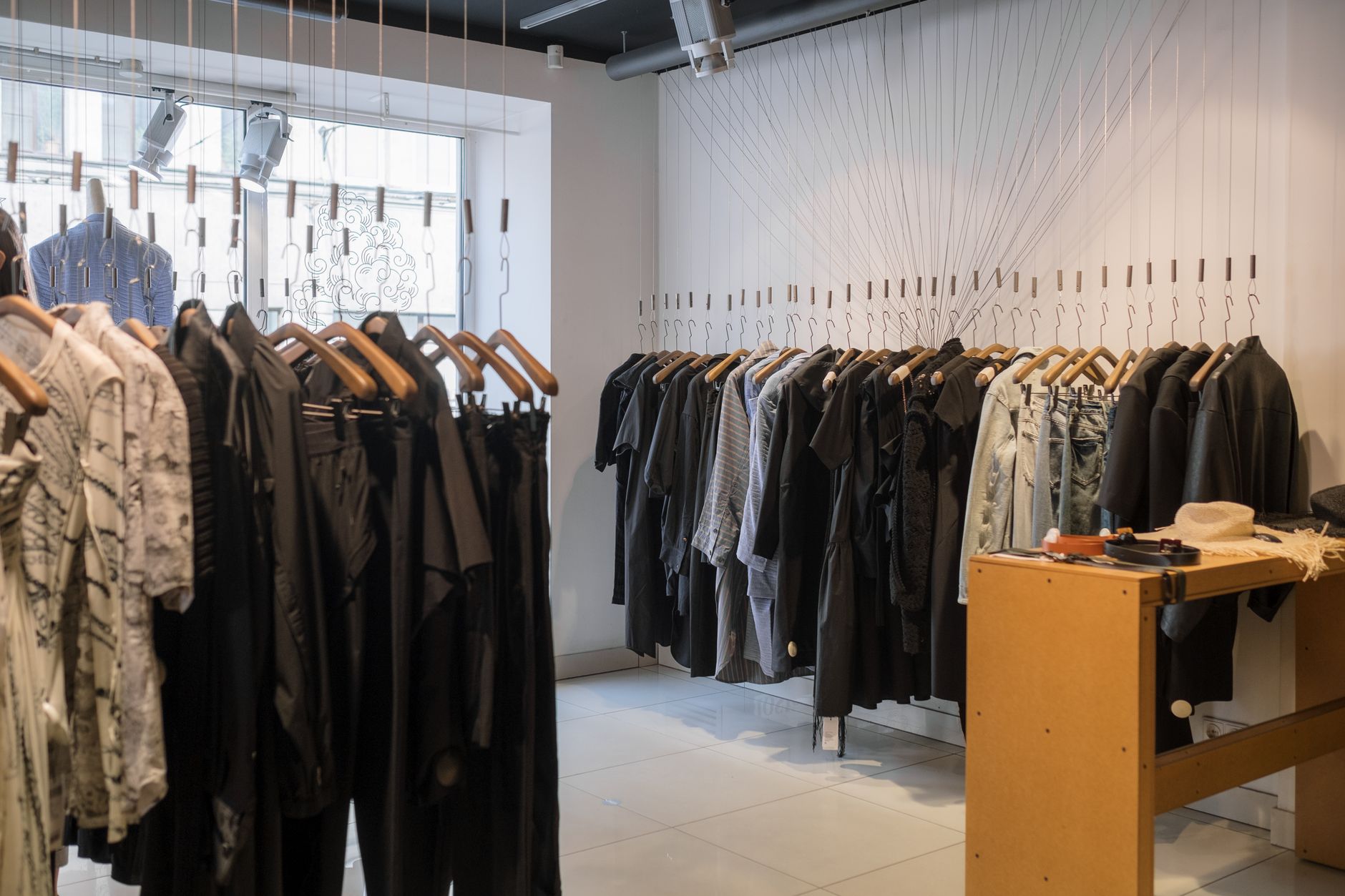 Clean, minimal fashion boutique interior with organized clothing displays