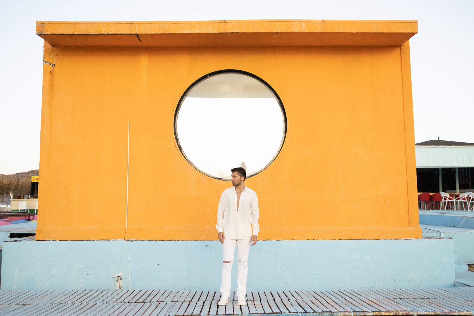 Man wearing tailored trousers styled with a casual knit in a minimal setting