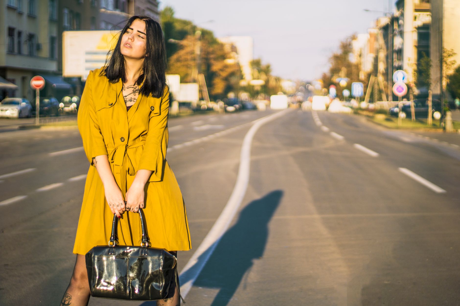 A fashion-forward outfit with a small shoulder bag worn on a city street