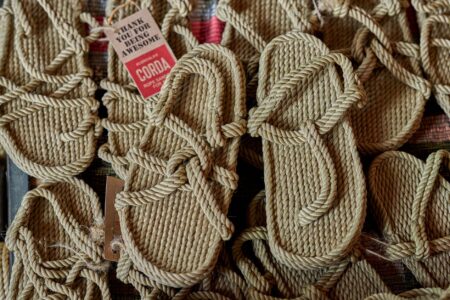 The Fisherman Sandal Is Quietly Edging Out the Strappy Heel Close-up of brown leather fisherman sandals on a wooden surface
