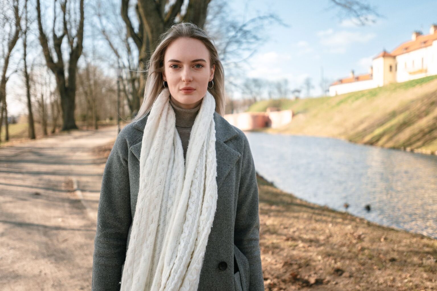 A neatly folded merino tube scarf in a neutral tone laid flat on a light surface