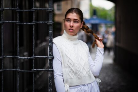 A ribbed knit vest styled over a white collared shirt, worn as a layering piece