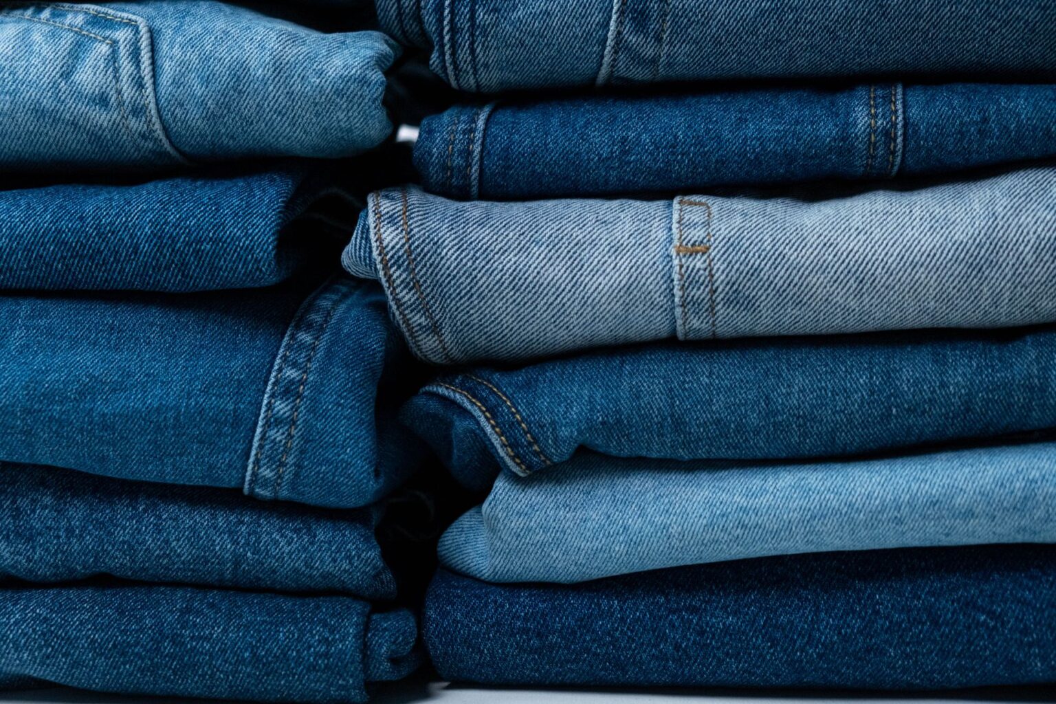 Close-up of distressed denim jeans with raw hem detailing on a model