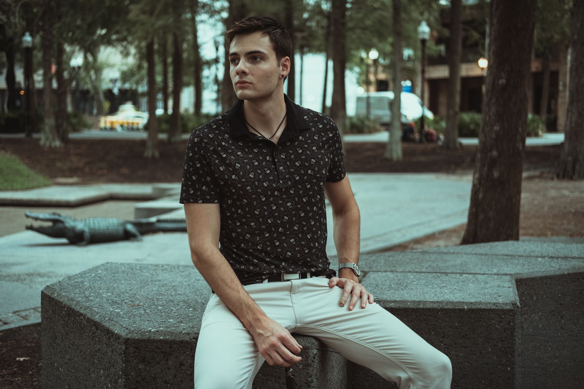 A neatly folded knit polo shirt in a neutral tone displayed on a flat surface