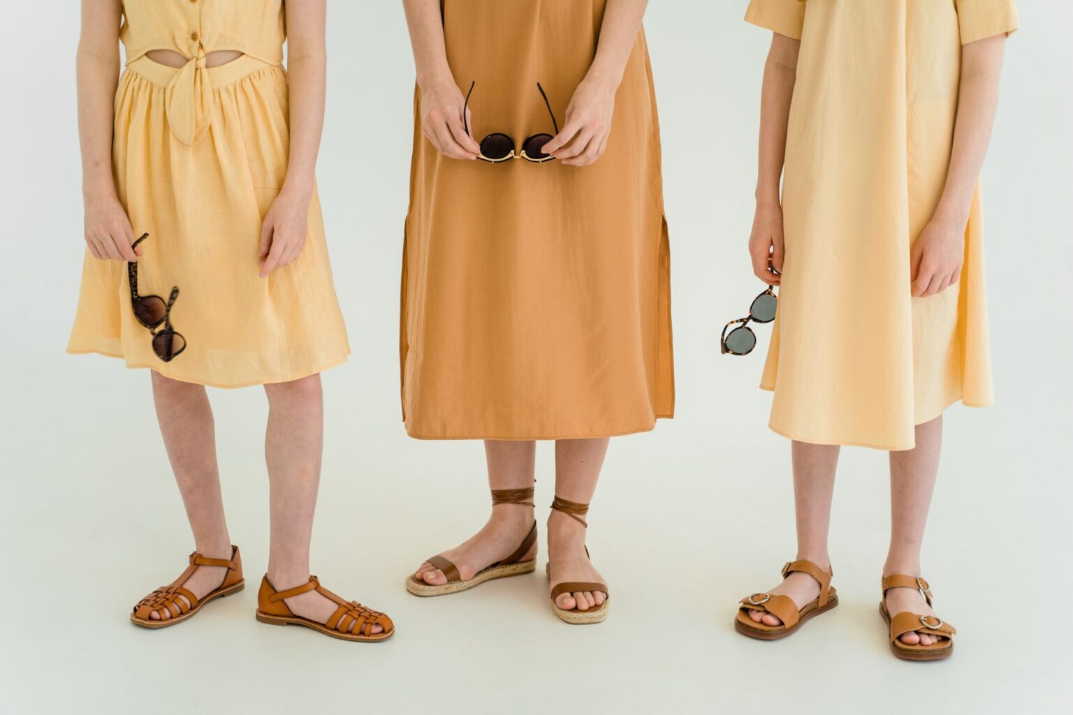 The Wrap Flat Is Quietly Edging Out the Ankle-Strap Sandal Close-up of wrap flat sandals with tie details on a woman's feet against a light background