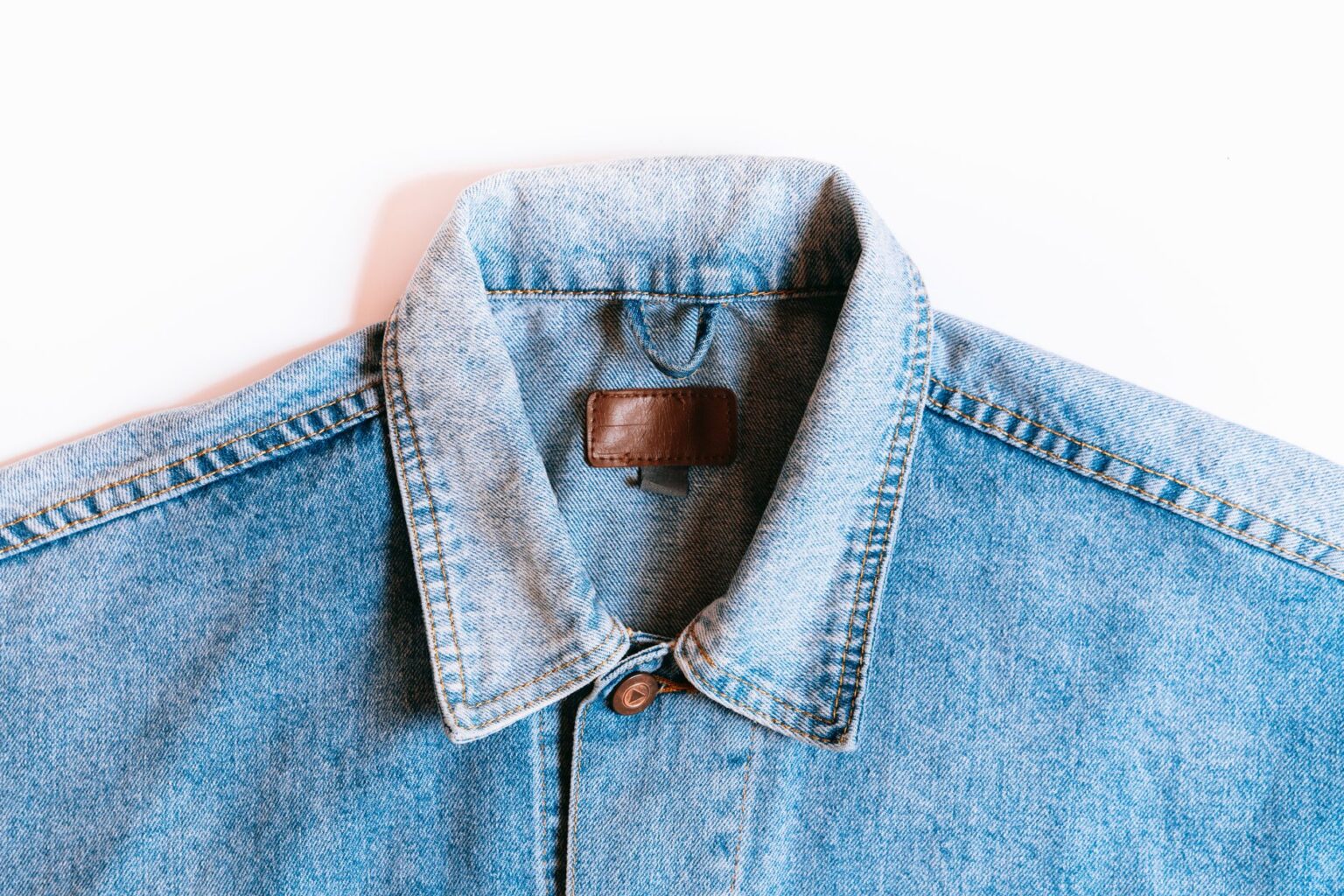 The Broderie Anglaise Jacket Is Quietly Edging Out the Denim Overshirt A white broderie anglaise jacket laid flat on a neutral surface showing eyelet embroidery detail