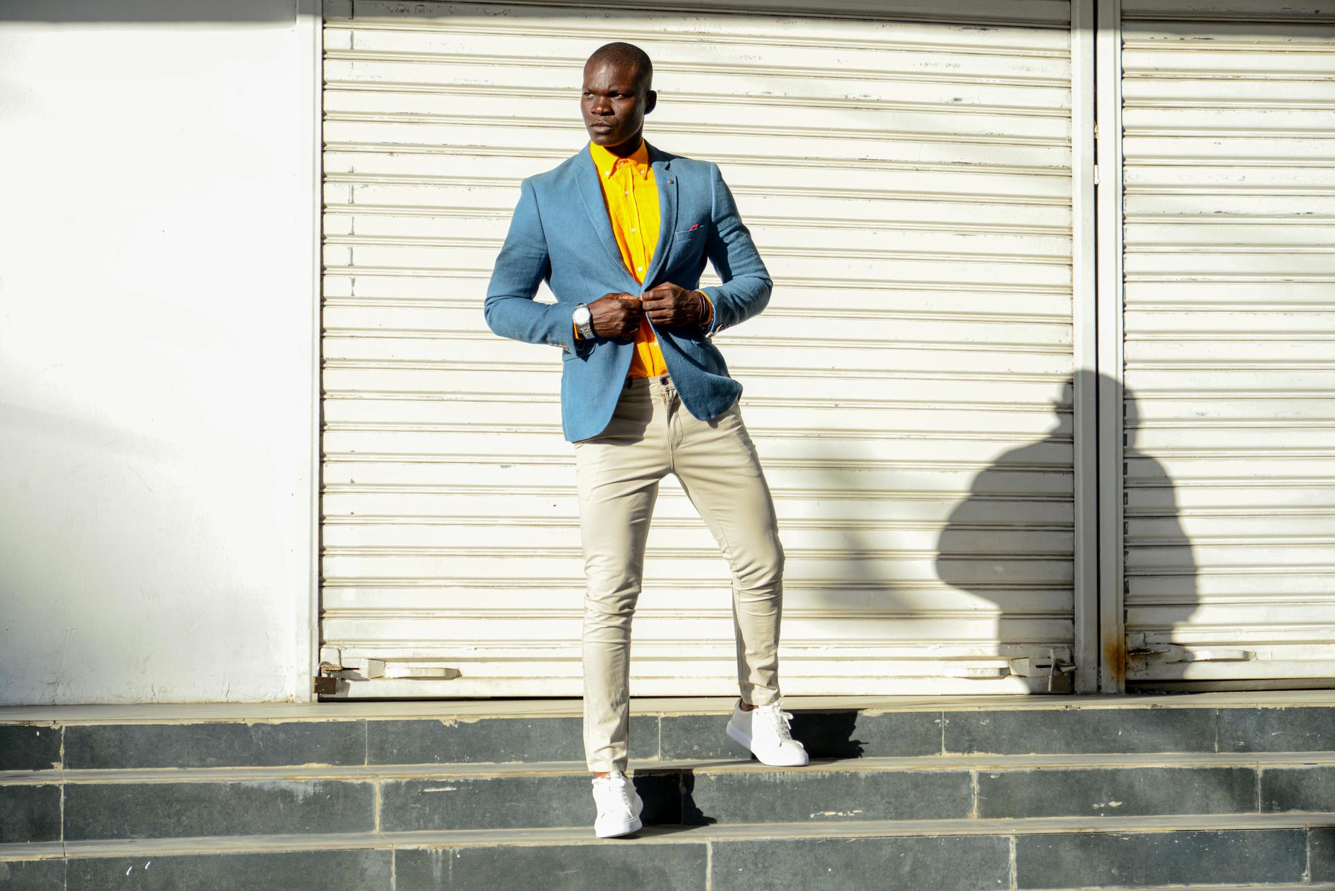 A man wearing a relaxed linen blazer over a t-shirt with denim trousers