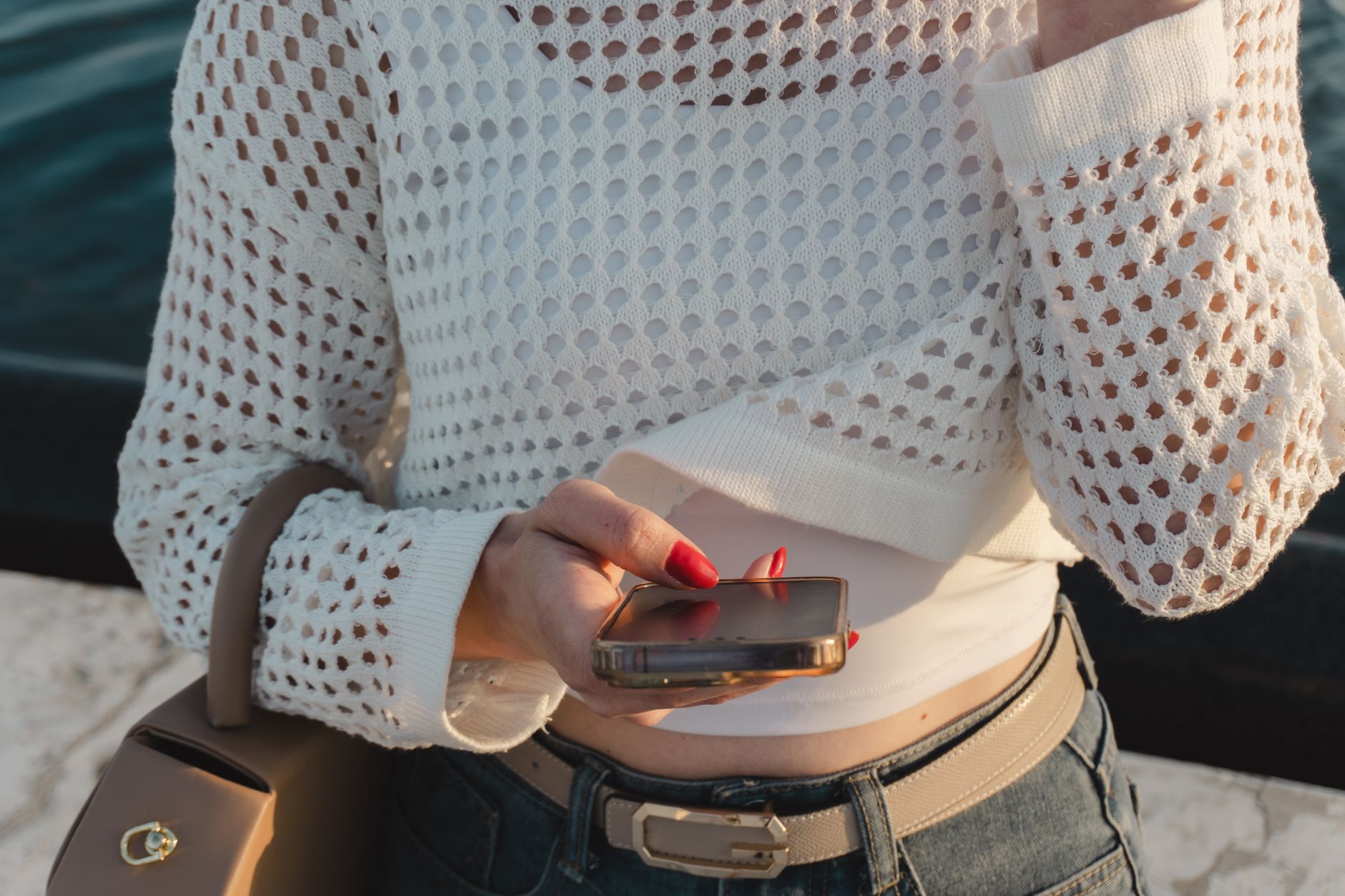 A woman wearing a light textured jacket over a simple outfit in warm weather