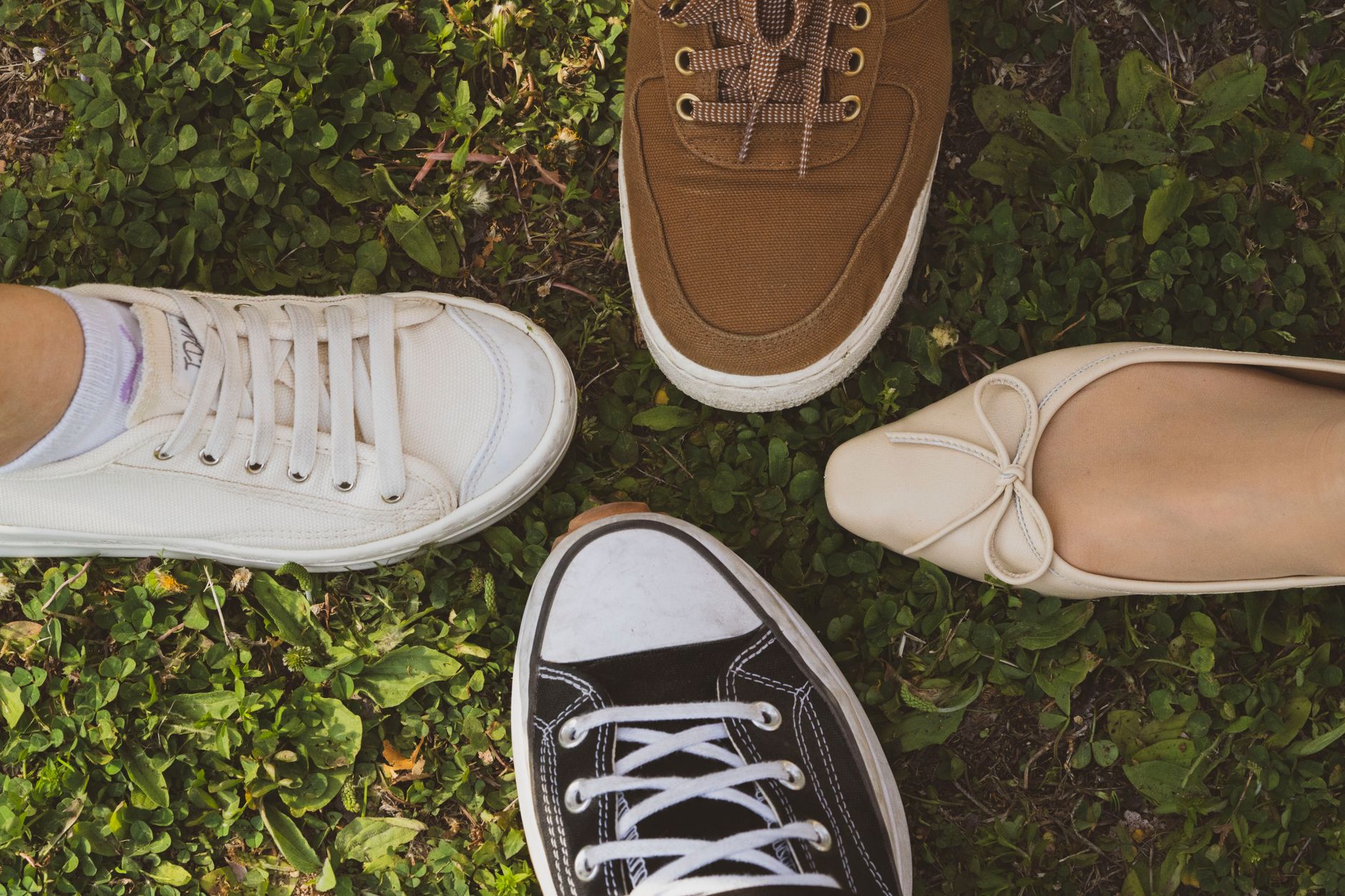 Close-up of strappy kitten heels and mule shoes side by side on a wooden surface