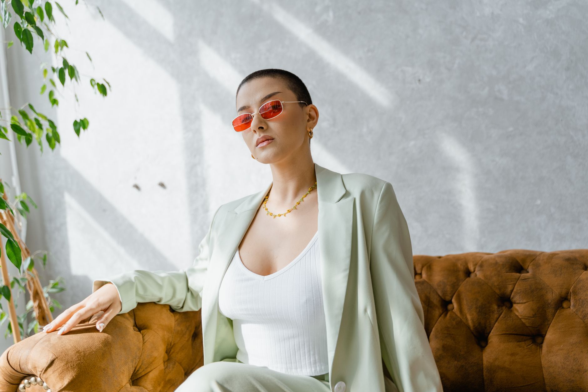 A woman wearing an oversized linen blazer over a light dress in a minimal setting