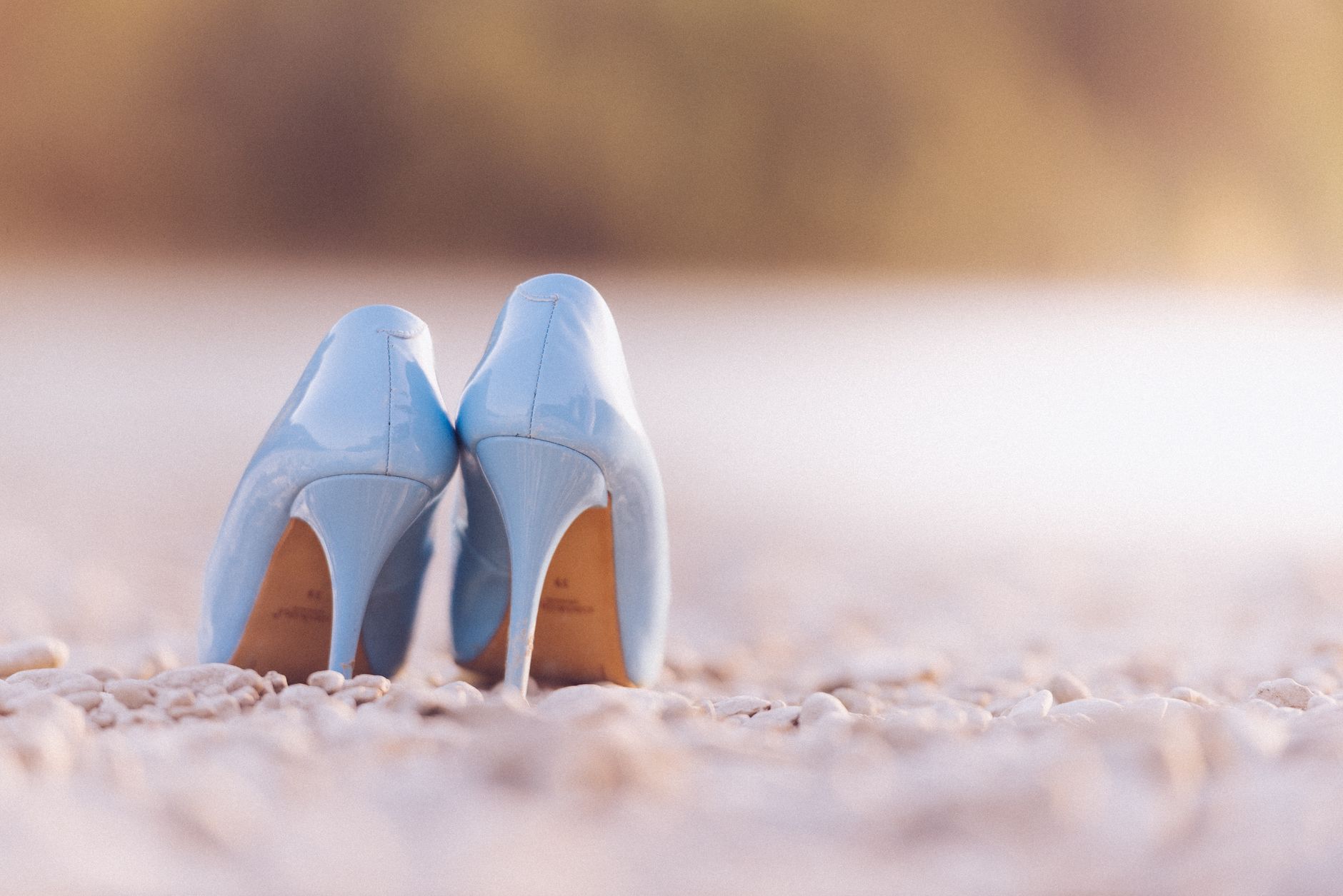 A pair of pointed-toe kitten heel slingback shoes on a neutral background