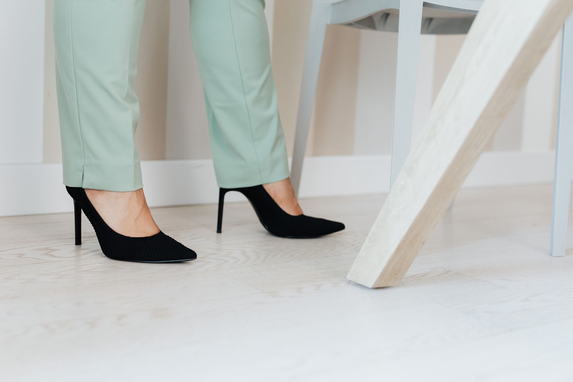 A woman wearing a tailored outfit styled with pointed-toe mules for a polished look